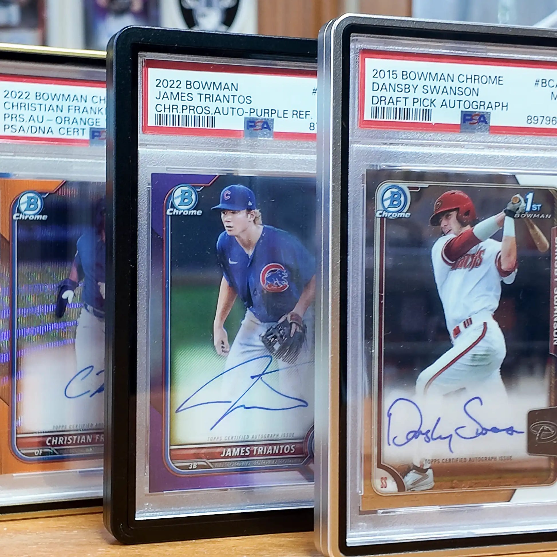 Trio of PSA-graded trading cards displayed in FlexDeez wall-mount cases