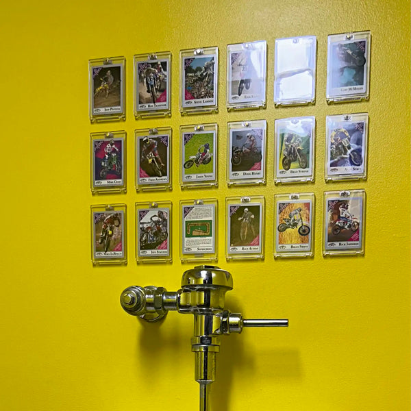 PSA graded card in FlexDeez frame mounted above urinal