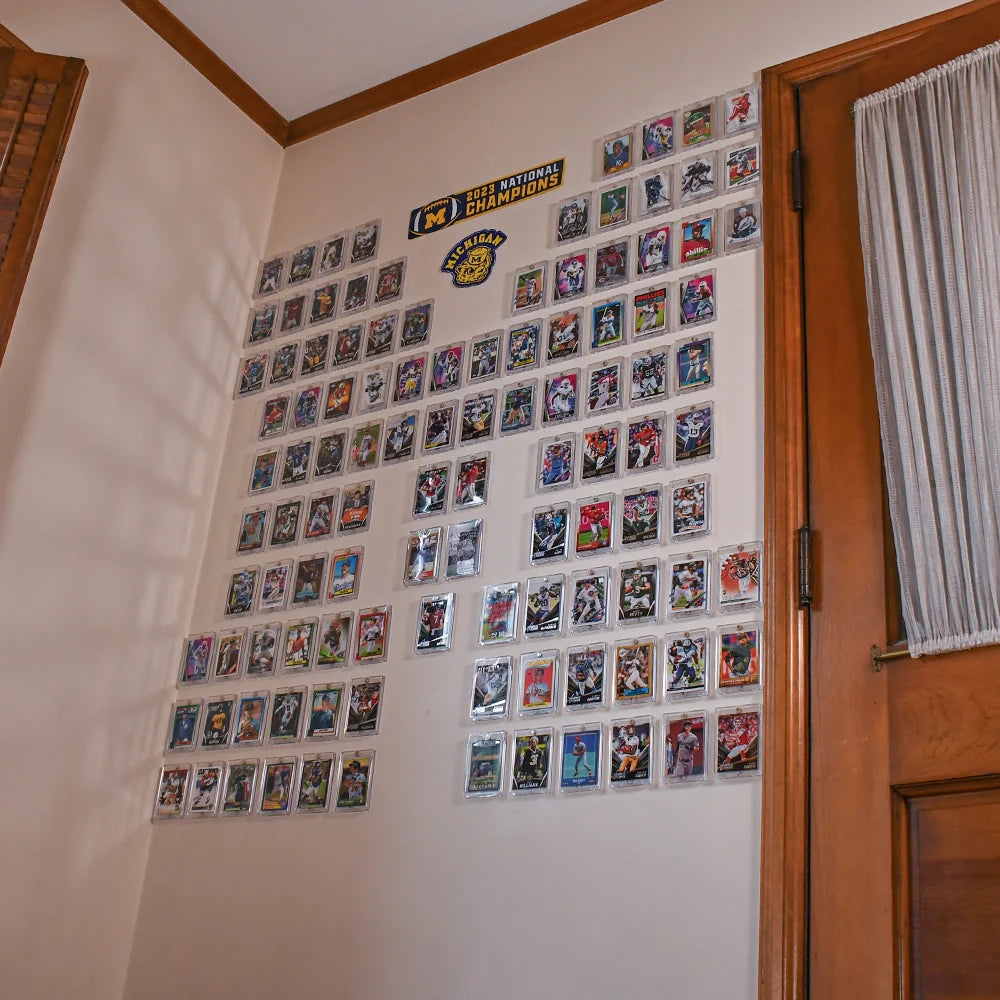 Trading cards arranged in an “M” shape using FlexDeez wall-mounted display system under Michigan signs